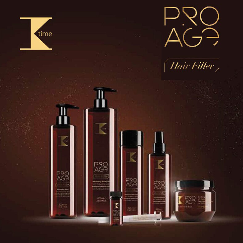 Conjunto de productos capilares en envases marrón ámbar con detalles dorados y el logo "K" y la marca "PRO AGE", dispuestos sobre fondo marrón e incluyendo dos botellas con dispensador, un frasco alto, un spray, un bote con tapa, un vial y una jeringa, transmitiendo diseño elegante y alta calidad.
