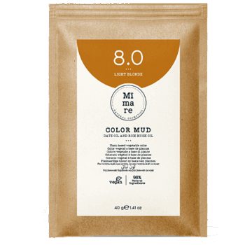 Sobre de papel kraft con etiqueta blanca y semicírculo naranja que identifica un producto de tintura capilar, logotipo circular y pequeños iconos que indican composición vegetal y carácter vegano, presentado como de alta calidad y con precio accesible.