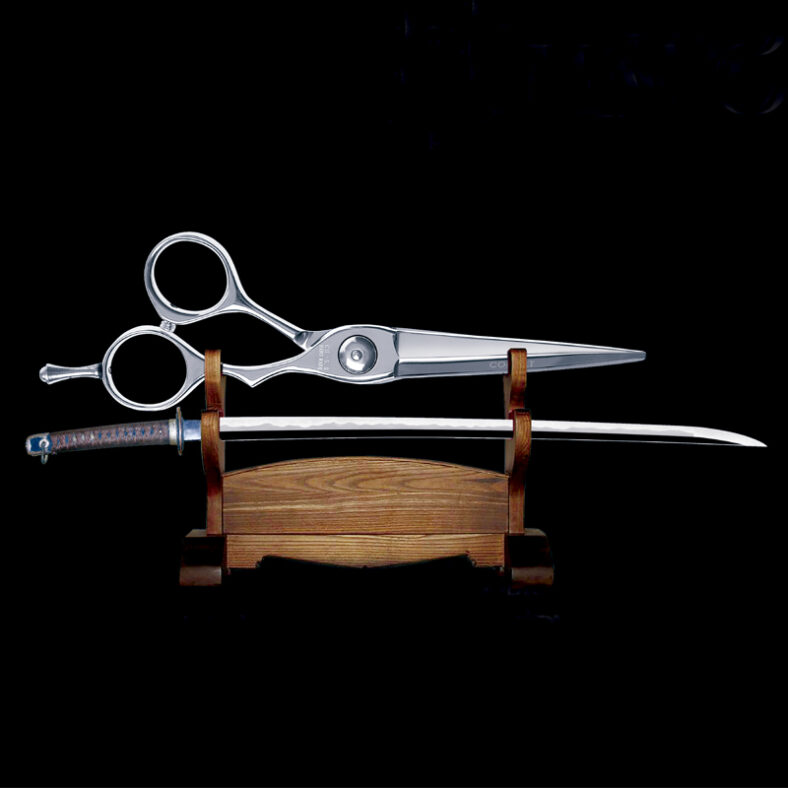 Tijeras de acero pulido con asas circulares y reposadedos descansando sobre una katana japonesa de hoja con hamon y empuñadura envuelta, ambas exhibidas en un soporte de madera sobre fondo negro, imagen de alta calidad.