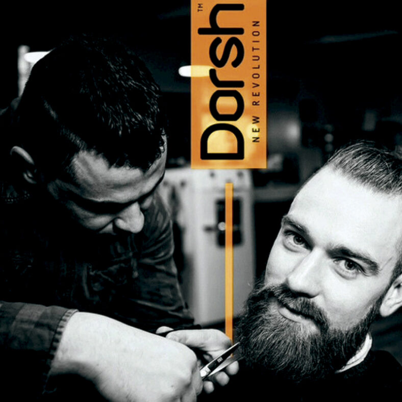 Barbero concentrado recortando con tijeras la barba de un cliente que mira a cámara en un salón, mostrando cuidado profesional y un ambiente moderno ideal para arreglos de barba.