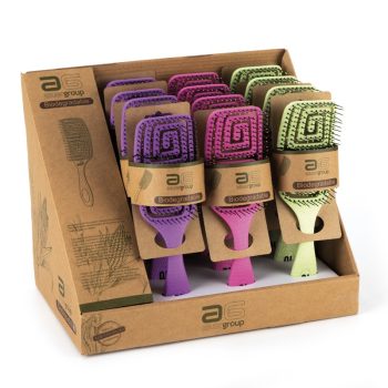 Exhibidor de cepillos de paleta biodegradables en tonos morado, rosa y verde con cerdas y empaques de cartón, ideal para uso profesional y presentado como una atractiva oferta en caja de mostrador.