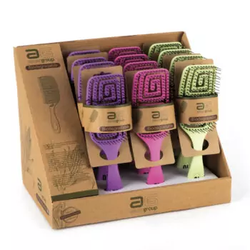 Exhibidor de cepillos de paleta biodegradables en tonos morado, rosa y verde con cerdas y empaques de cartón, ideal para uso profesional y presentado como una atractiva oferta en caja de mostrador.