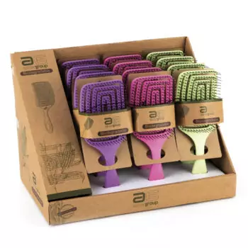 Expositor de cepillos acolchados biodegradables en colores morado, rosa y verde con púas negras y embalaje de cartón reciclado, pensado para profesionales que valoran un acabado profesional y sostenible.