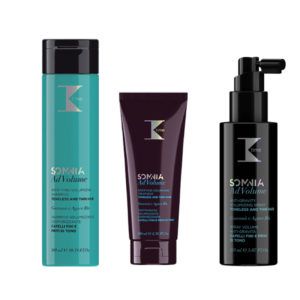 Conjunto de tres envases sobre fondo blanco —un frasco turquesa de champú, un tubo morado oscuro de tratamiento y un dosificador negro de spray— para volumen capilar (champú, tratamiento y spray) presentados como productos de alta calidad.