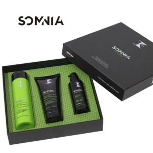 Set de cuidado personal presentado en caja negra con interior verde que contiene tres productos (un frasco alto verde, un tubo negro y un dispensador negro), mostrado de manera profesional y de alta calidad.