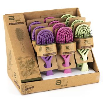 Expositor de cartón con múltiples cepillos para el cabello biodegradables en tonos morado, rosa y verde, presentados en embalaje individual y listos para venta en peluquería.