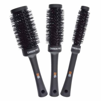 Tres cepillos redondos de distintos diámetros en acabado negro mate con barriles ventilados y cerdas densas, dispuestos sobre fondo blanco y pensados para un peinado profesional con volumen.