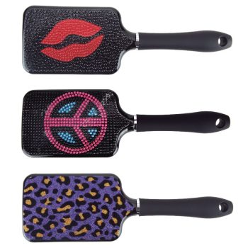 Tres cepillos tipo pala para peluquería con mangos negros: el superior adornado con labios rojos de pedrería, el central con símbolo de paz en brillantes rosas y azules, y el inferior con estampado leopardo morado y dorado.