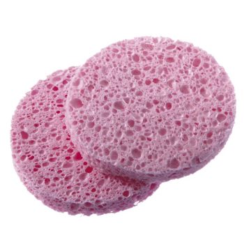 Dos discos esponja circulares rosados con textura muy porosa y agujeros irregulares, superpuestos sobre fondo blanco, apariencia suave y absorbente para uso cosmético profesional.
