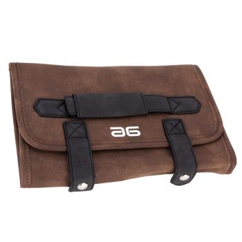 Bolsa enrollable de cuero marrón con asas y correas negras con remaches, pensada para guardar herramientas de peluquería de alta calidad.