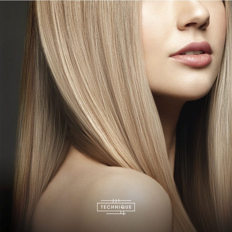 Primer plano de perfil parcial de una mujer con piel suave y labios naturales y cabello rubio, liso y brillante cayendo sobre el hombro, iluminado con acabado de alta calidad.