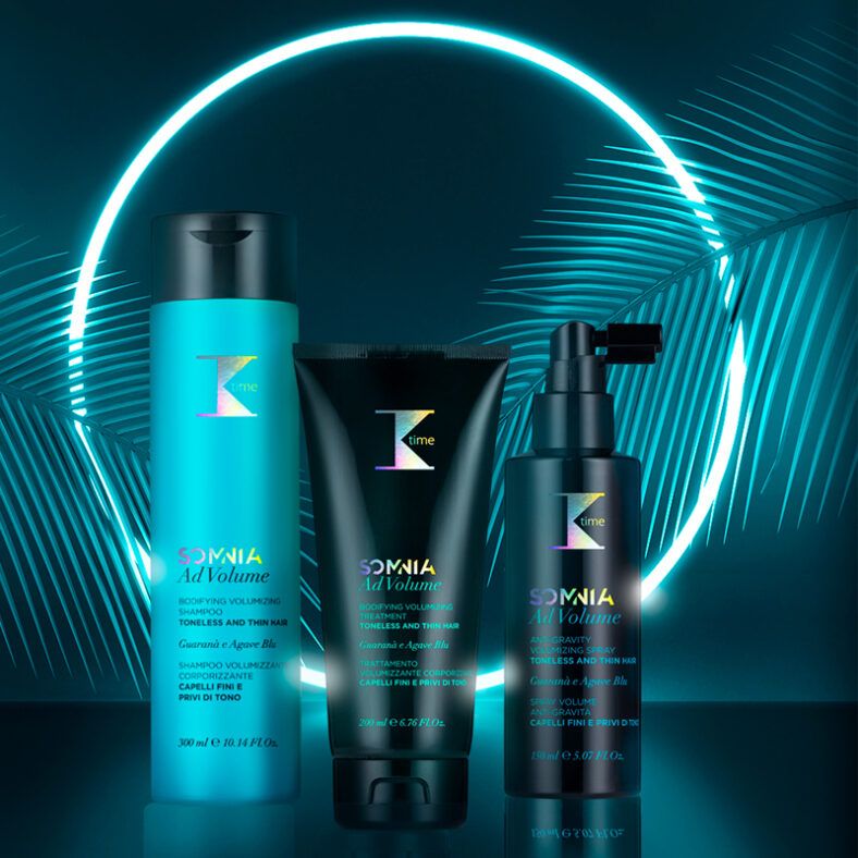 Tres envases de productos capilares en turquesa y negro dispuestos sobre una superficie reflectante frente a un fondo oscuro con un aro de luz neón y hojas de palma, presentación elegante de alta calidad.