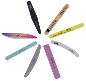 Varios modelos de limas y pulidores de uñas de colores y tamaños dispuestos en círculo sobre fondo blanco, accesorios para manicura y peluquería.
