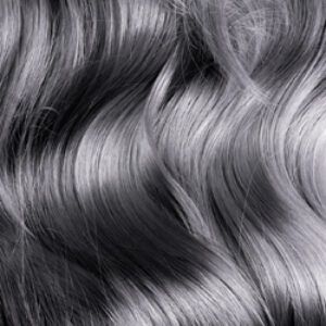 Cabello ondulado en primer plano con mechones plateados y brillantes que resaltan la textura suave y un acabado profesional.