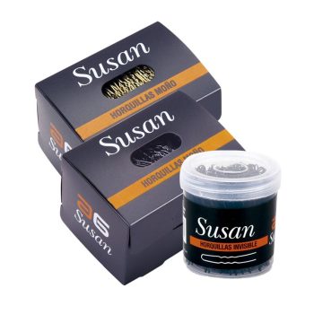 Cajas negras con franja naranja y un bote transparente que muestran horquillas para moño e invisibles con el nombre Susan, presentadas para uso profesional.