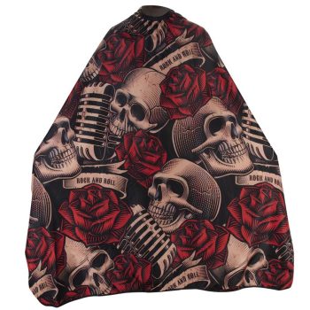 Capa de peluquería negra con estampado repetido de calaveras estilizadas, rosas rojas y micrófonos retro sobre cintas con la leyenda "Rock and Roll", diseño llamativo pensado para uso profesional.
