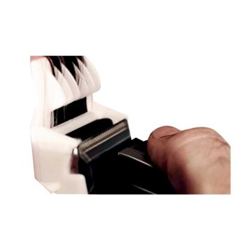 Primer plano de una mano ajustando la cuchilla metálica de una recortadora eléctrica junto a peines plásticos apilados, que sugiere un acabado 'profesional'.