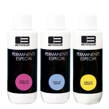 Tres frascos blancos de producto "Permanente Especial" de la marca BETICOLOR con etiquetas negras y círculos rosa, azul y amarillo que indican "cabellos normales", "cabellos fuertes" y "cabellos sensibles", colocados en fila, peluquería.