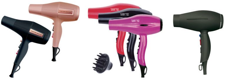 Varios secadores de pelo de colores (negro, rosa, rojo y verde) con mangos ergonómicos, botones visibles y un difusor accesorio, dispuestos juntos para profesionales.