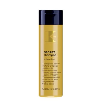 Envase cilíndrico amarillo con tapa negra y etiqueta que indica 'SECRET shampoo sulfate free' con lista de beneficios impresos, presentado como producto capilar de 'alta calidad'.