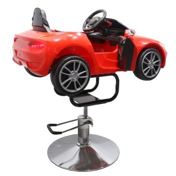 Silla infantil en forma de coche rojo montada sobre una base hidráulica cromada con reposapiés, volante y puerta abierta, ideal para peluquería.