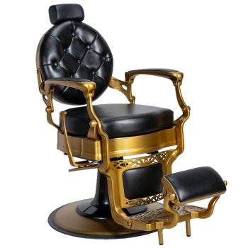 Silla de barbero vintage de alta calidad con tapizado negro capitoné, armazón y reposabrazos dorados ornamentados, reposacabezas y reposapiés acolchados sobre base circular.