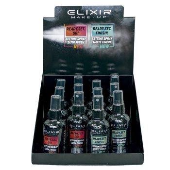 Expositor negro con doce botes transparentes de spray fijador Elixir Make-Up con dos variantes identificables por etiqueta — "Ready.Set.Go!" de acabado satinado y "Ready.Set.Finish!" de acabado mate — dispuesto como un exhibidor completo para uso profesional.