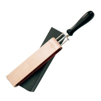 Correa de cuero para afilar con mango negro y armazón metálico apoyada sobre una base negra, útil para trabajo profesional, con una composición evidente de cuero, metal y madera.