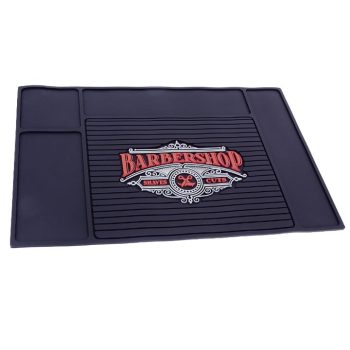Tapete antideslizante negro para barbería de alta calidad con ranuras centrales, compartimentos laterales y logotipo rojo y blanco con icono de tijeras.