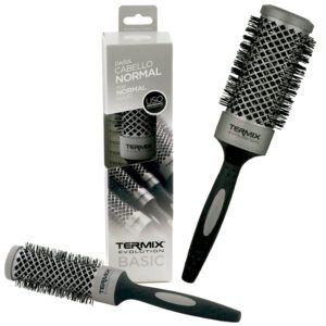 Un cepillo redondo térmico negro y gris con mango ergonómico y cerdas densas, mostrado en varias posiciones junto a su caja, diseñado para cabello normal y presentado como un producto de 'alta calidad'.