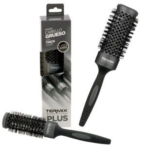 Cepillo redondo negro con cuerpo de rejilla y cerdas firmes, mango ergonómico y su caja que muestra "para cabello grueso" y "uso profesional", pensado para conseguir el mejor peinado al secado.