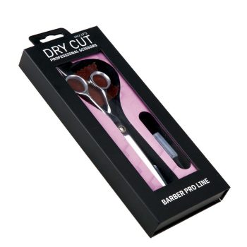 Tijeras de peluquería plateadas visibles en estuche negro con ventana transparente y fondo rosa, etiquetadas como profesional y parte de la línea para barbería.