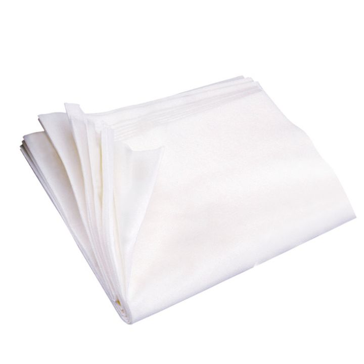 Pliegos de tela blanca doblados y apilados con pliegues nítidos y textura lisa, aspecto uniforme de alta calidad y apariencia autorizada.